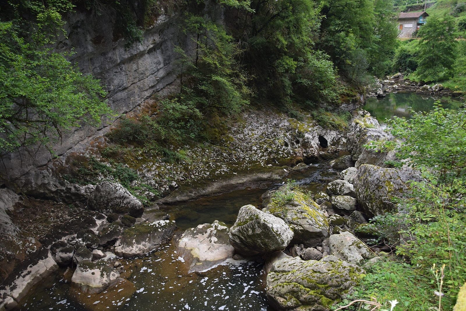 Un cours d'eau et des parois rocheuses au site de la grotte du Mas-d'Azil